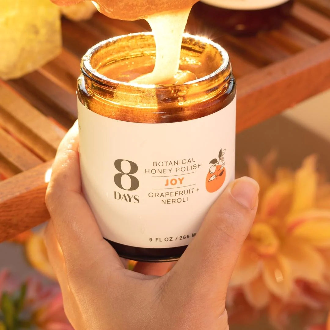 Woman filling a jar of 8 Days Botanicals Organic Body Polish - Joy.