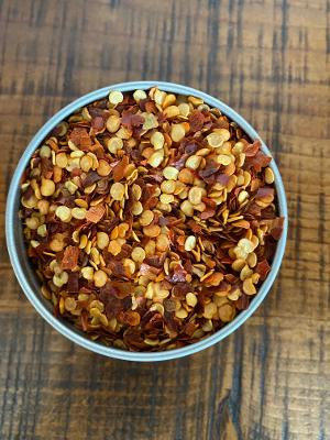 A top down look into a container of Organic Chili Flakes.