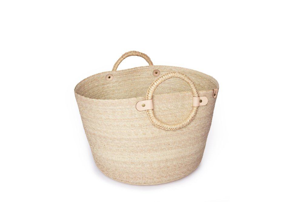 A Caminito Large Woven Floor Basket with round handles against a white background.